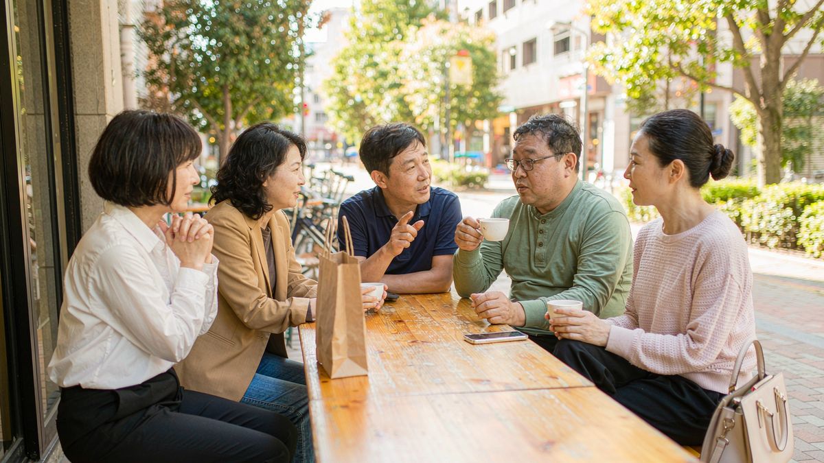 几位刚认识的朋友在户外咖啡馆轻松交流