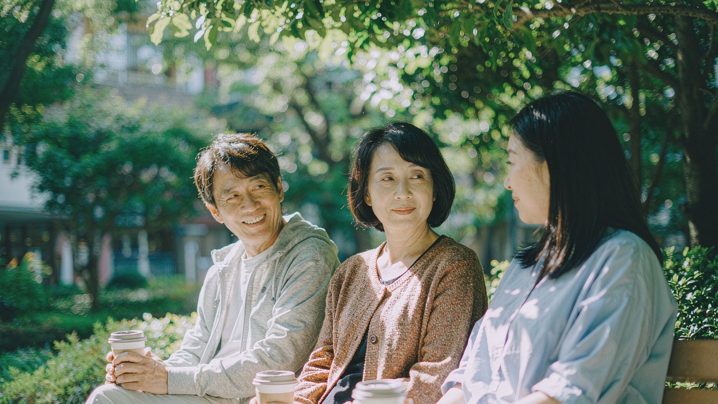 几位朋友在城市公园长椅上从容交谈